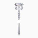 Side view of oval-cut moissanite ring with pavé band and halo-like prong basket