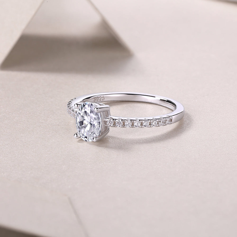 Engagement ring side profile with oval moissanite center stone and pavé row on band