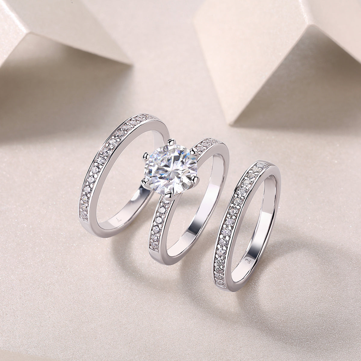 Three stacked rings with round center moissanite and pavé bands, angled top view