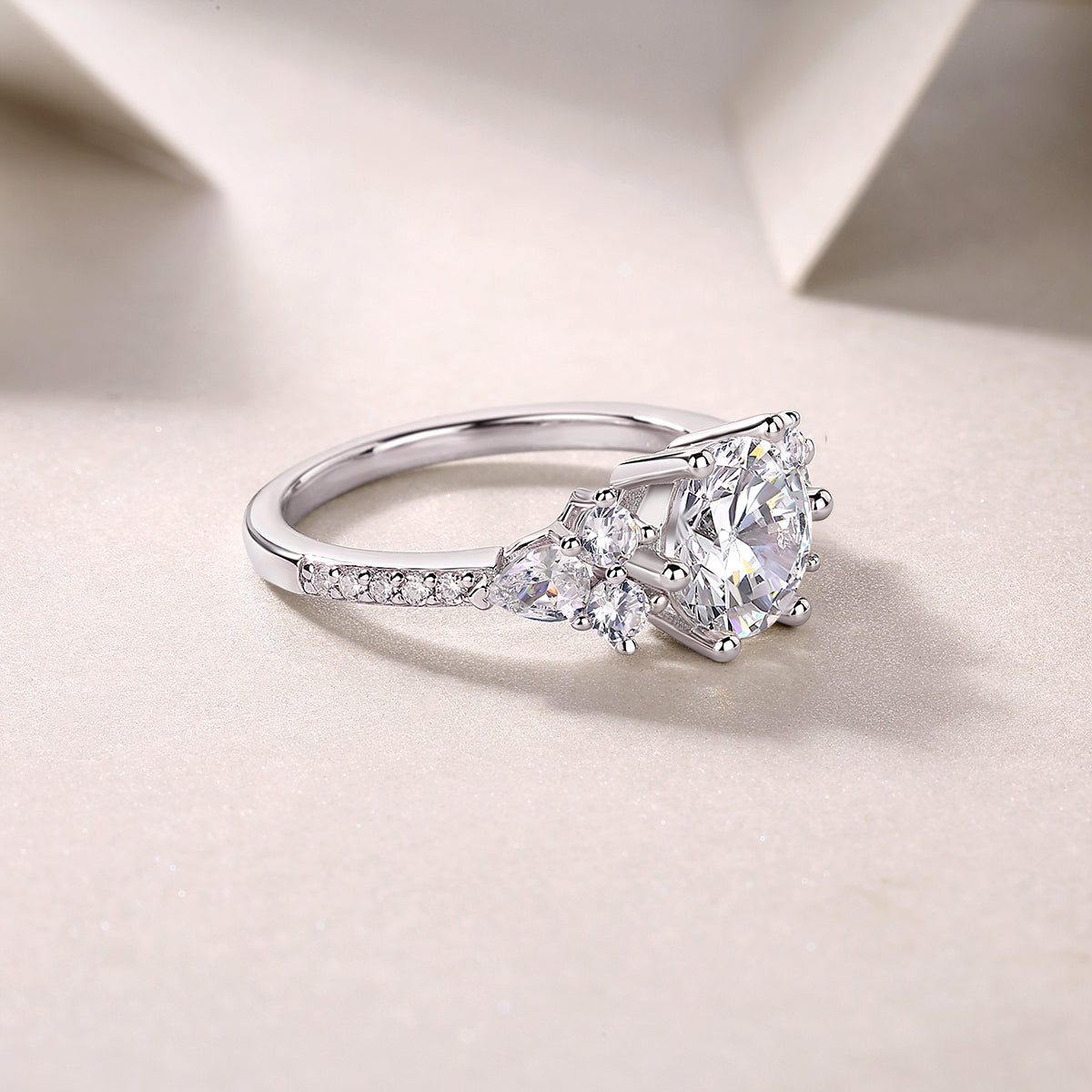 Round moissanite pavé ring with pavé band and clustered side stones, white gold