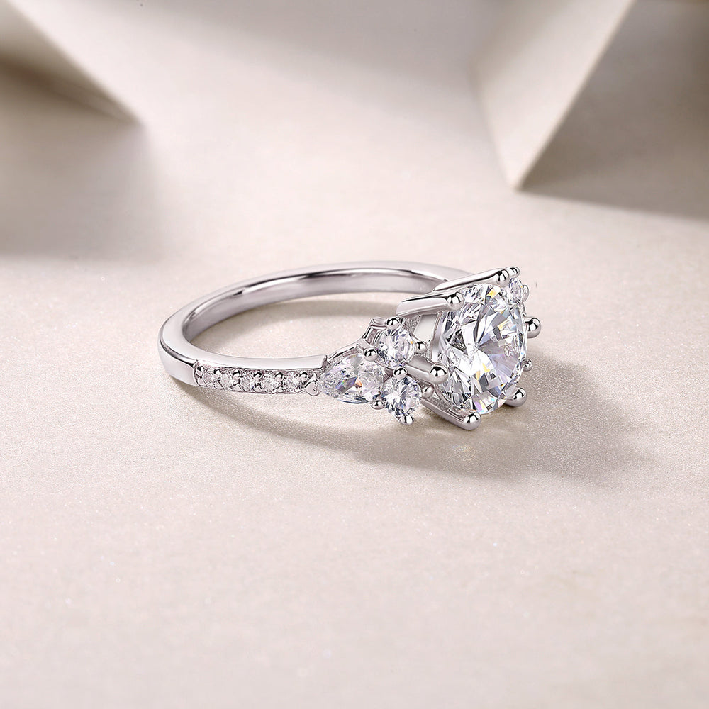 Round moissanite pavé ring with pavé band and clustered side stones, white gold