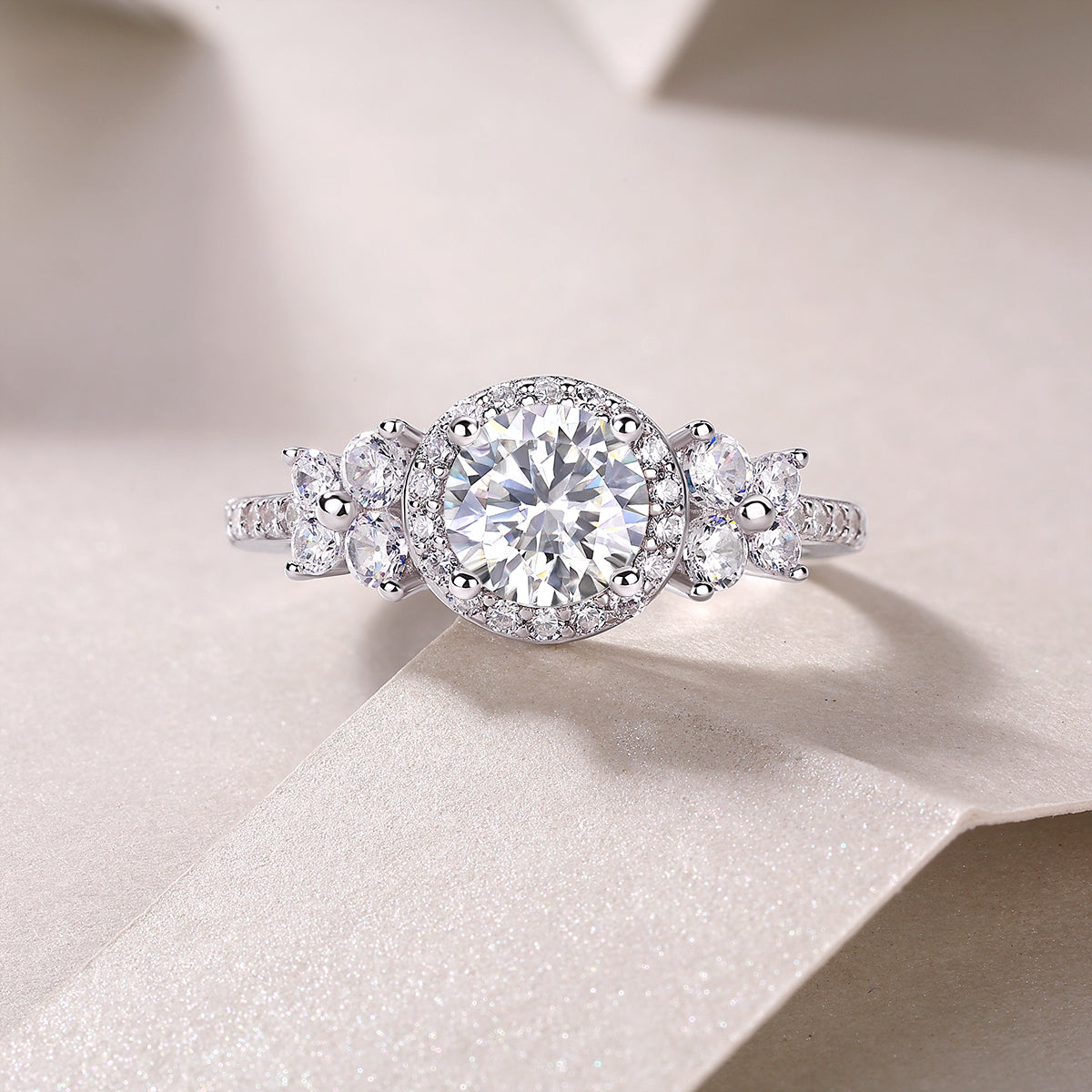 Close-up of round halo cluster moissanite ring with side stones and pavé detail