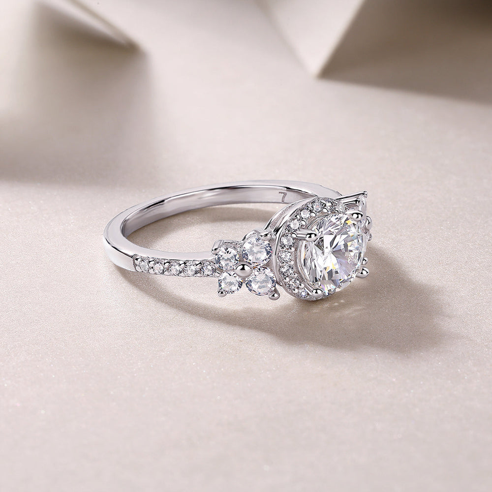 Profile view of round halo cluster ring with pavé side stones and prongs