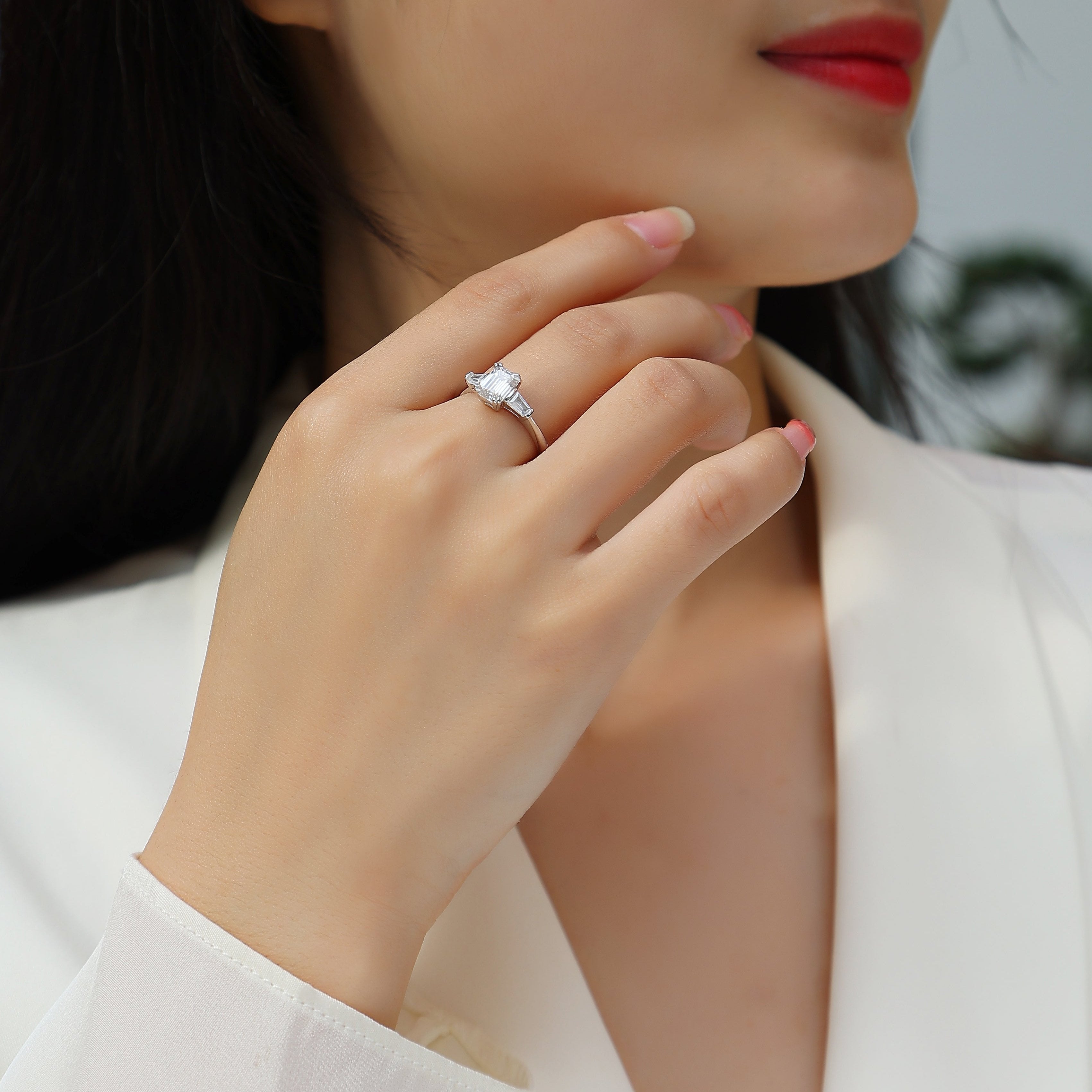 White gold vermeil three-stone emerald-cut moissanite engagement ring on hand