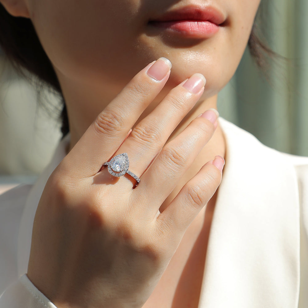 Pear-cut halo ring on hand, white gold vermeil band with pavé sparkle