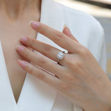 Asscher-cut solitaire moissanite ring on finger, halo and round side stones
