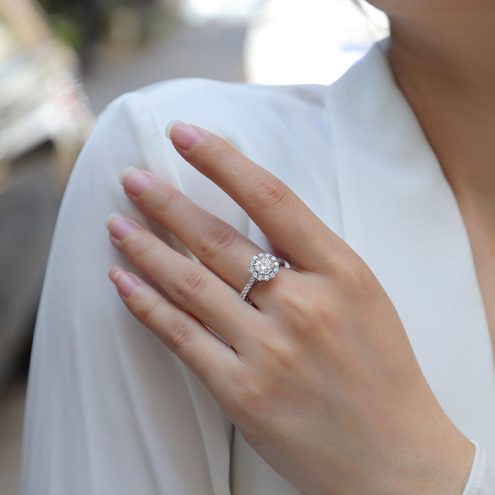 Halo moissanite engagement ring with pavé band on hand, white gold vermeil