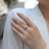 Halo moissanite engagement ring with pavé band on hand, white gold vermeil