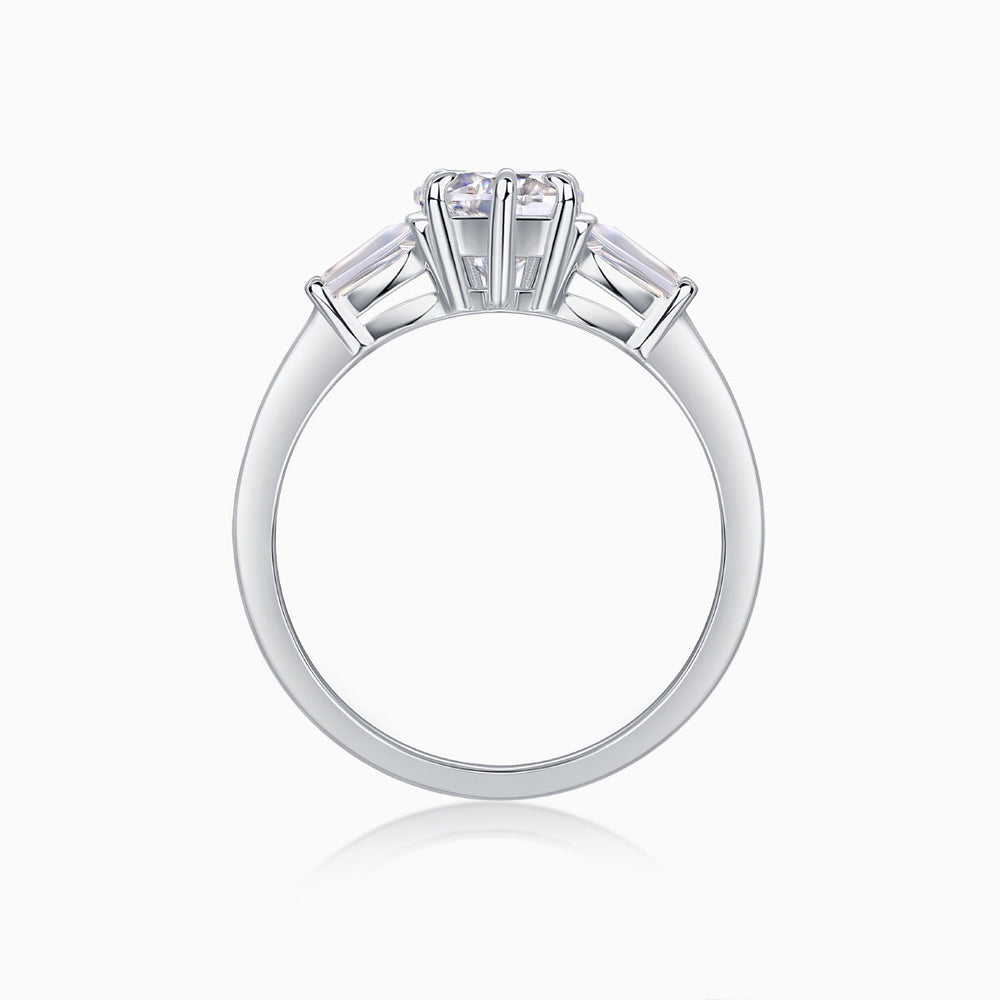 Three-stone moissanite ring top view from behind, prongs around heart-cut center stone