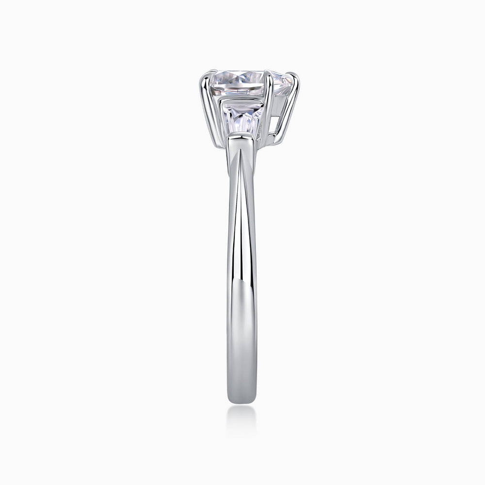 Three-stone moissanite ring profile with baguette side stones and tall prong-set heart-cut center