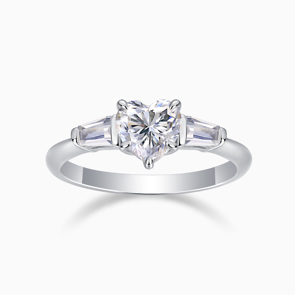 Three-stone moissanite ring with heart-cut center and baguette side stones, white gold tone band