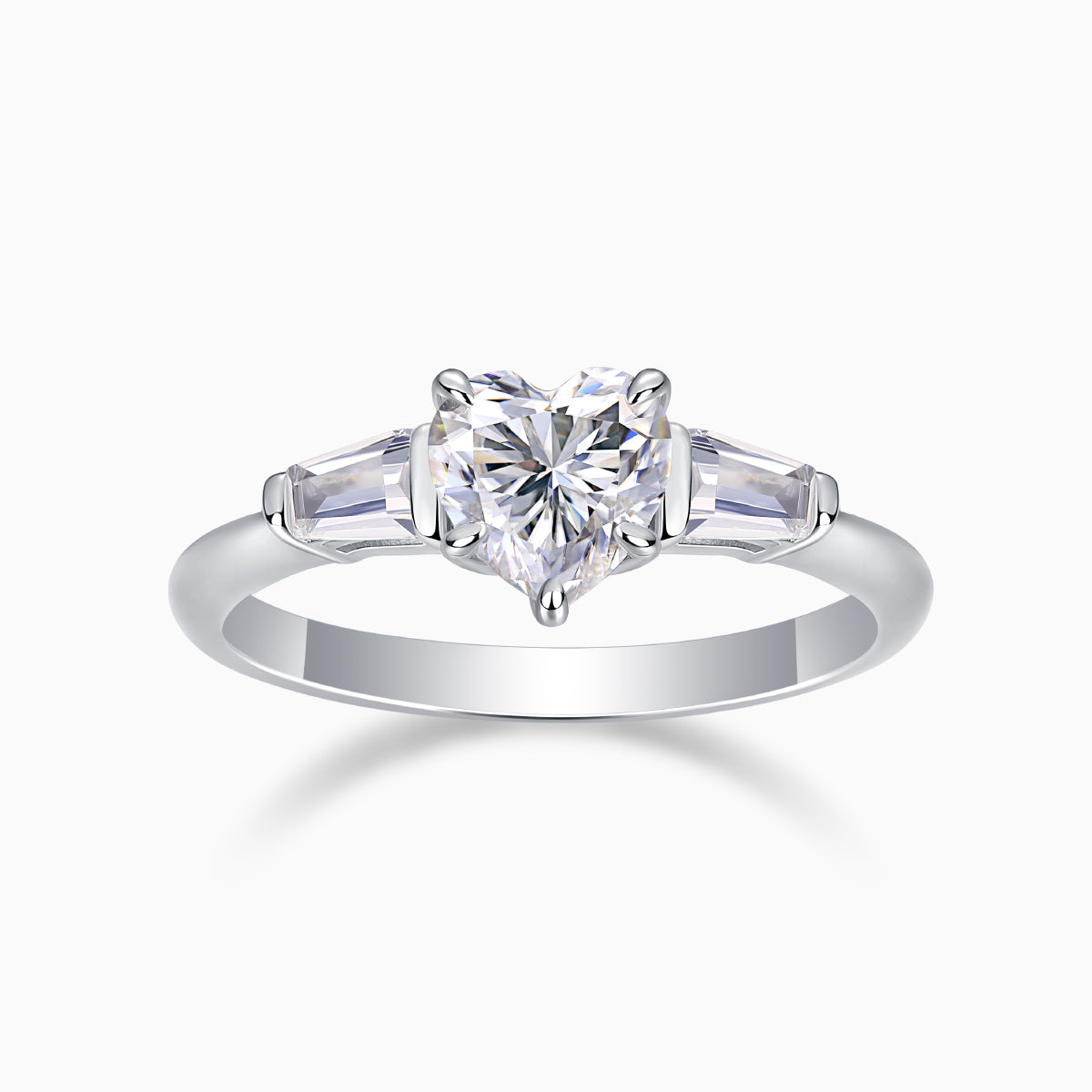 Three-stone moissanite ring with heart-cut center and baguette side stones, white gold tone band