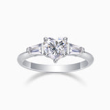 Three-stone moissanite ring with heart-cut center and baguette side stones, white gold tone band