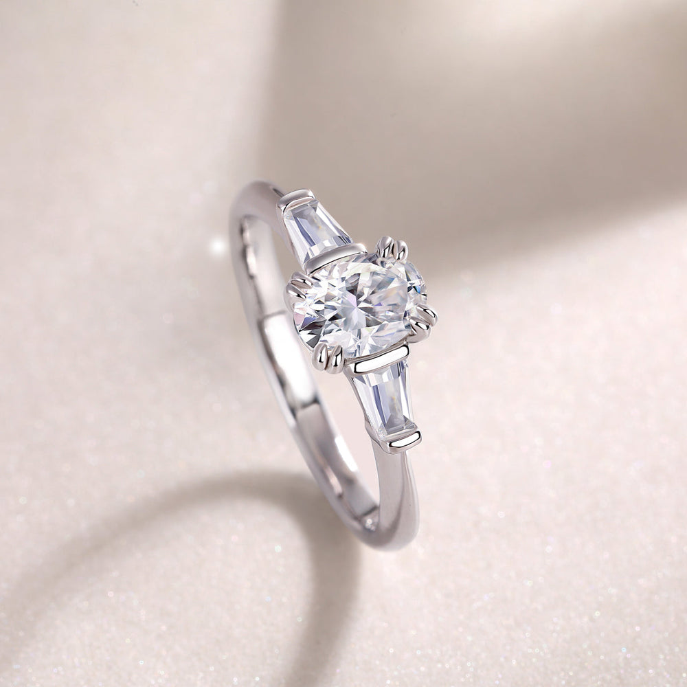 Side view: oval moissanite with baguette stones, white gold band and prongs