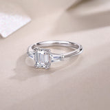 Three-stone emerald-cut moissanite engagement ring, white gold vermeil, side profile view