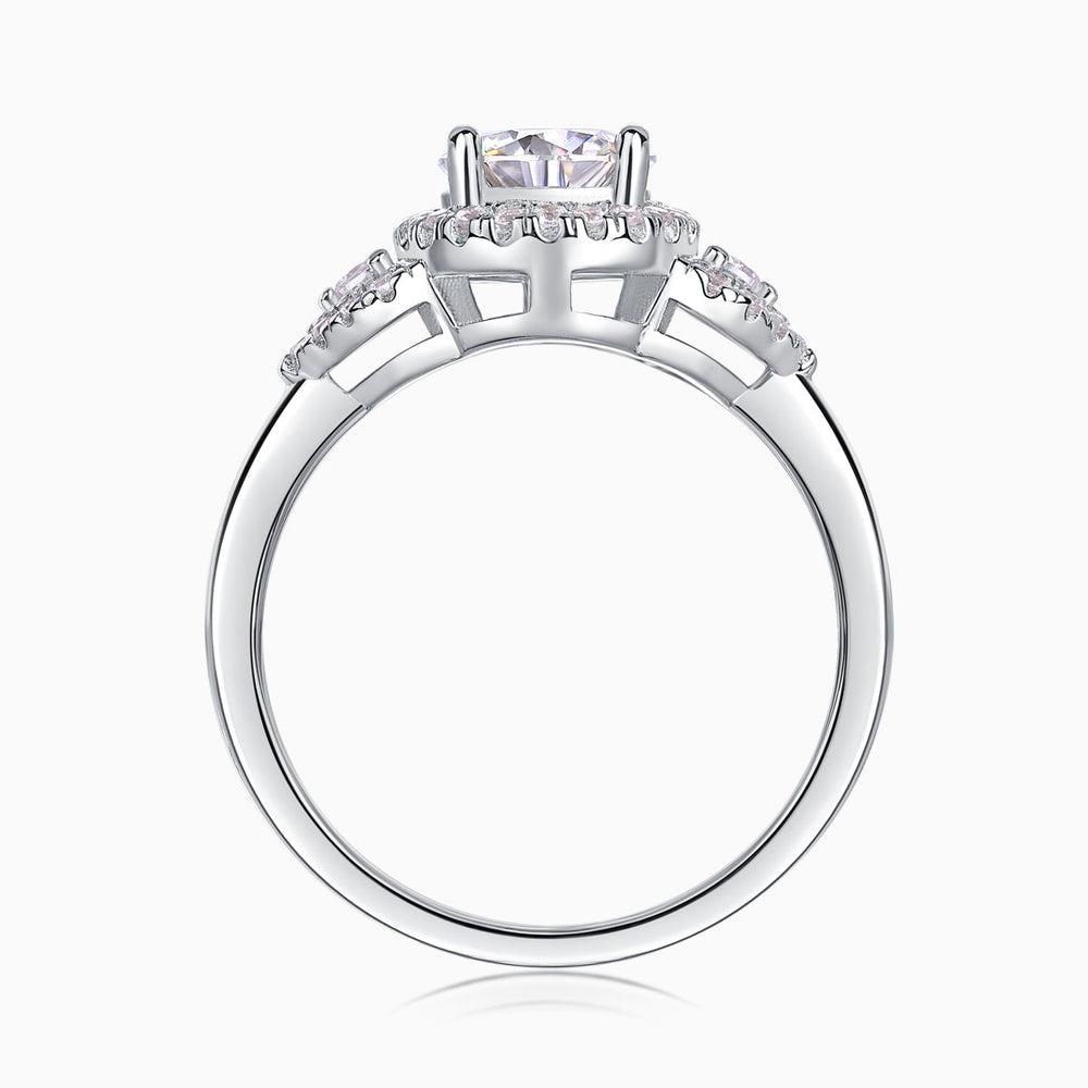 Profile view of moissanite halo engagement ring with prongs and pavé shoulders