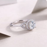 Round center moissanite with sculpted halo and pavé stones on white gold band