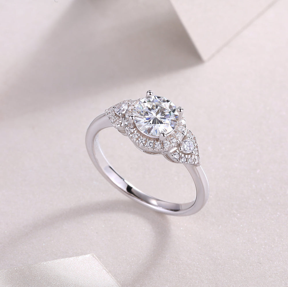 Round moissanite halo engagement ring with side pavé and raised center setting