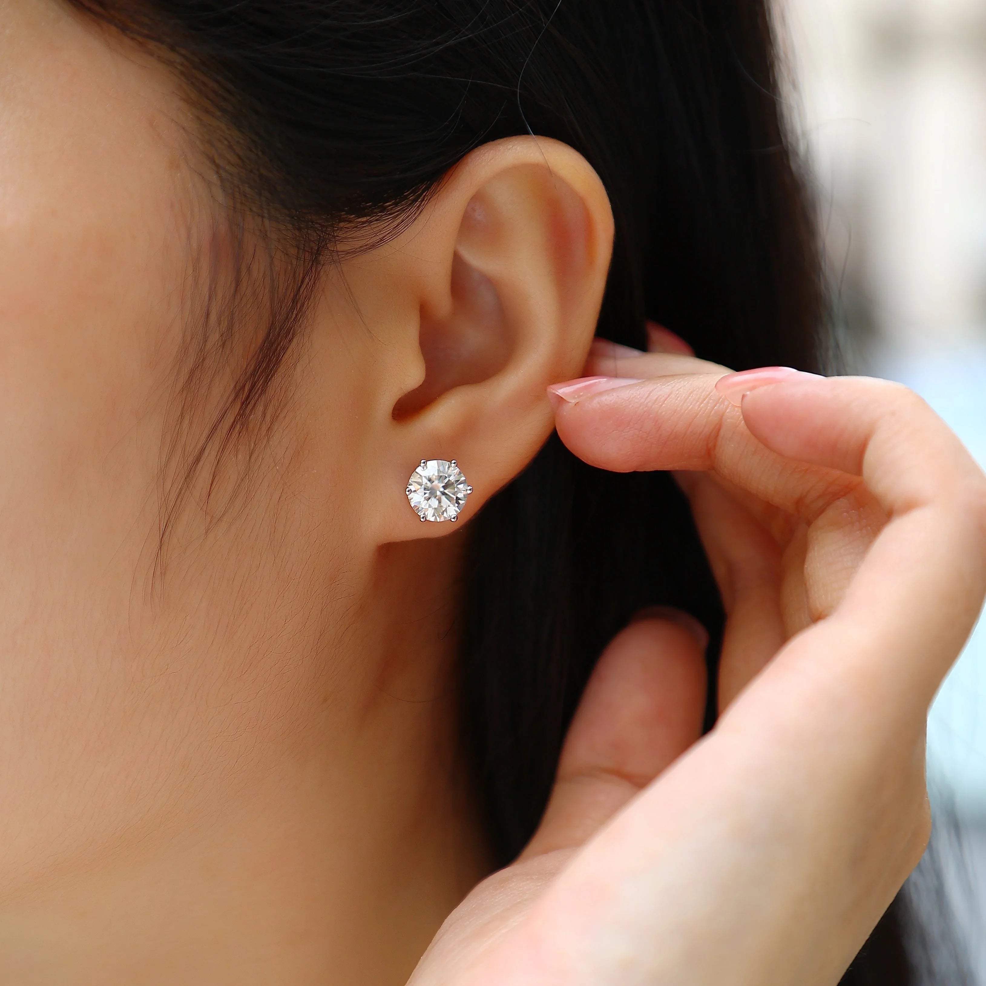 Moissanite solitaire stud earrings worn on ear, round stone with 6 prongs