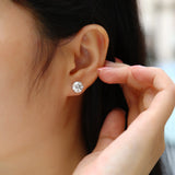 Moissanite solitaire stud earrings worn on ear, round stone with 6 prongs