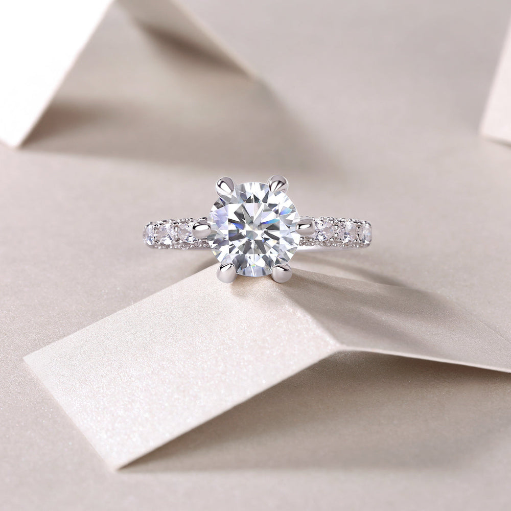 Moissanite engagement ring front view: round center stone in six-prong setting