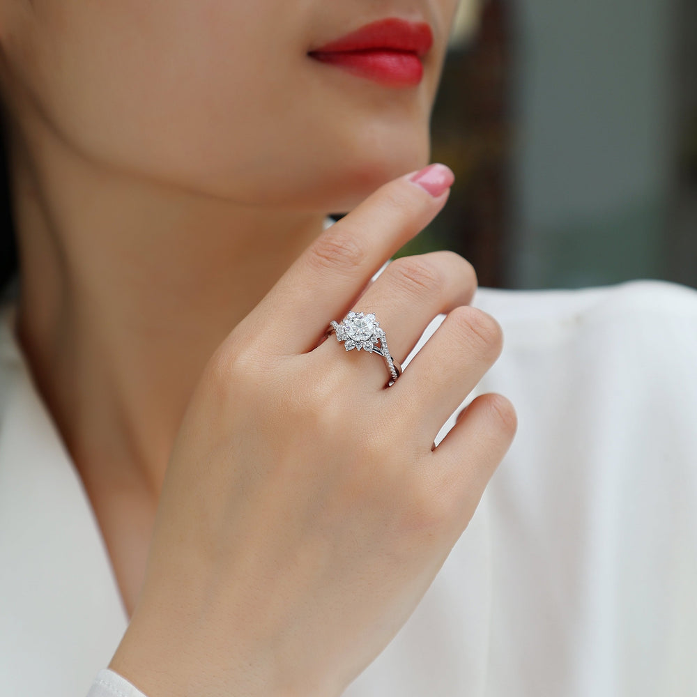 Moissanite halo engagement ring on finger; pavé twist split shank