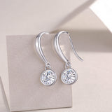Round moissanite drop earrings, bezel-set stones with small loop details