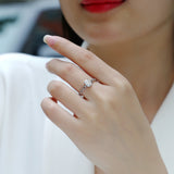 Oval moissanite chain ring on finger, oval center stone and linked band, white metal