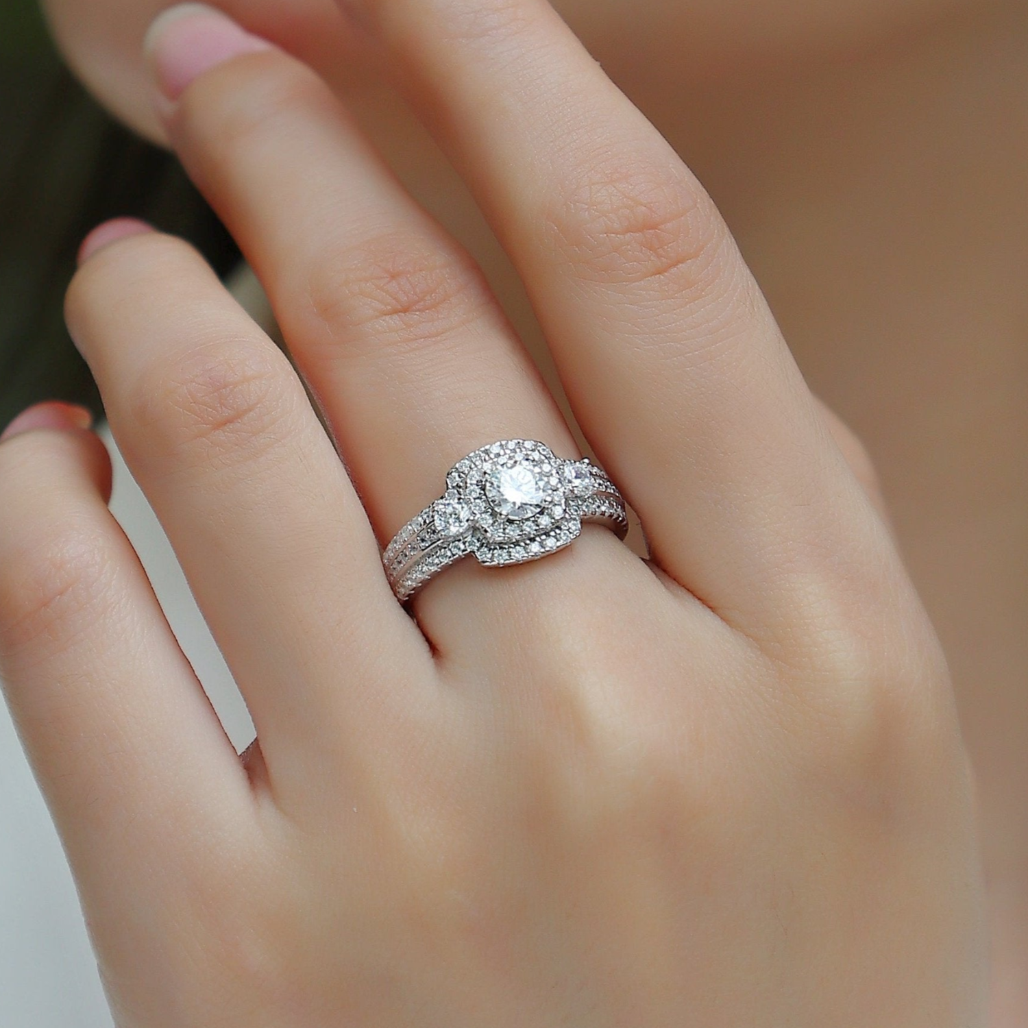 Square halo moissanite ring with pavé band, worn on finger