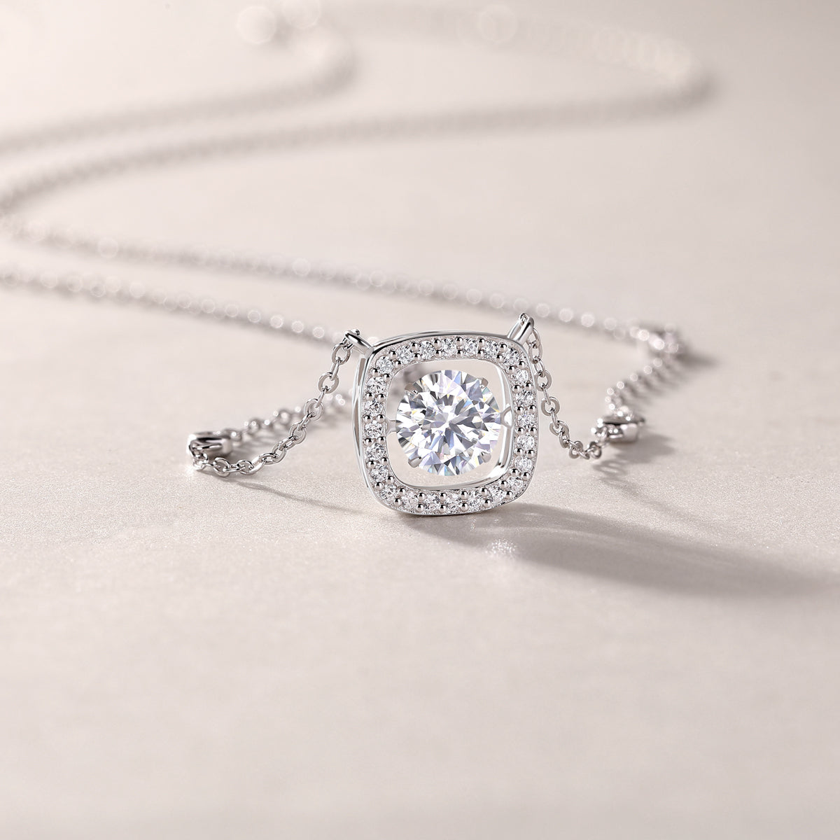 Cushion halo moissanite pendant close-up on station chain, white gold vermeil