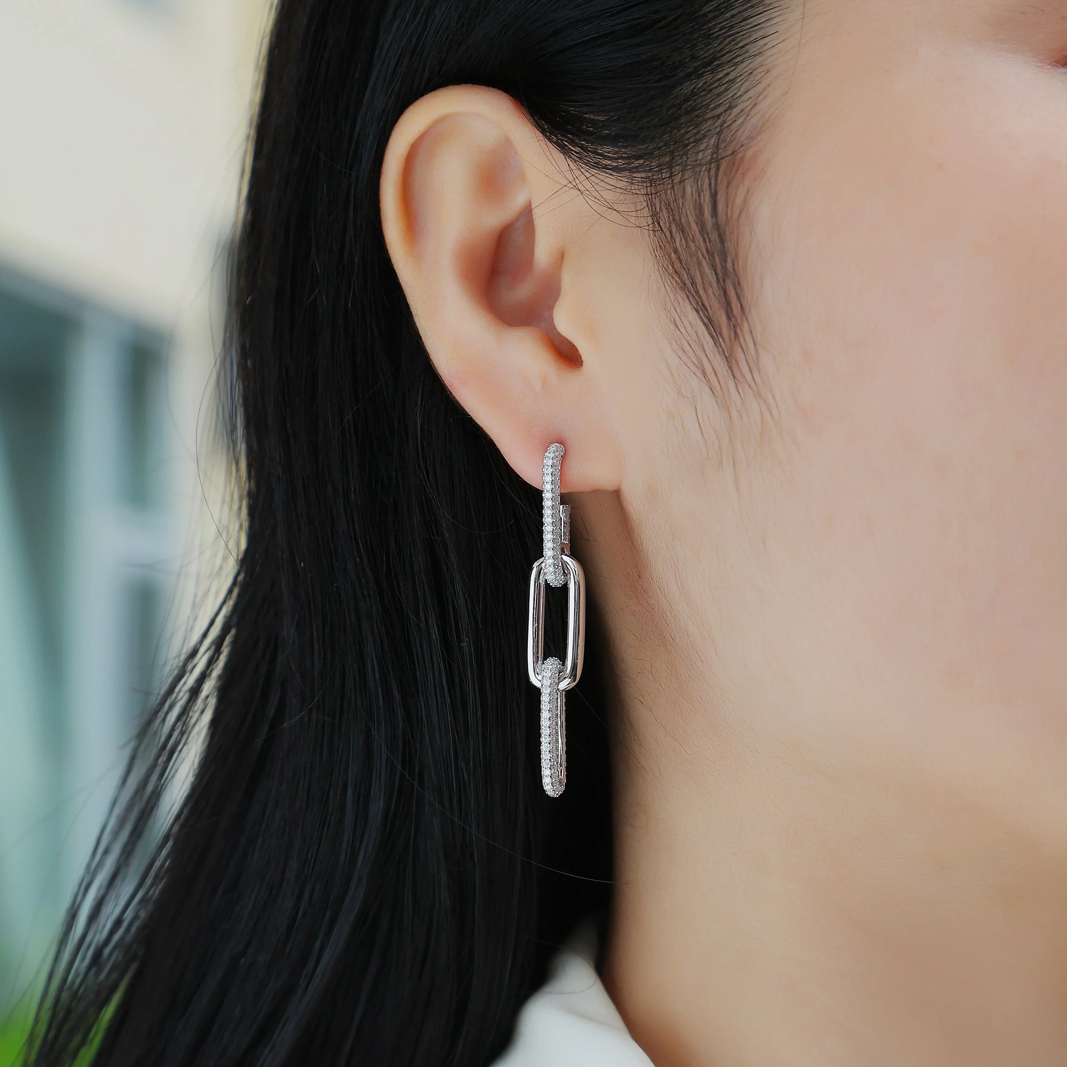 Sterling-toned drop earrings: pavé bar with hinged oval link, worn on ear