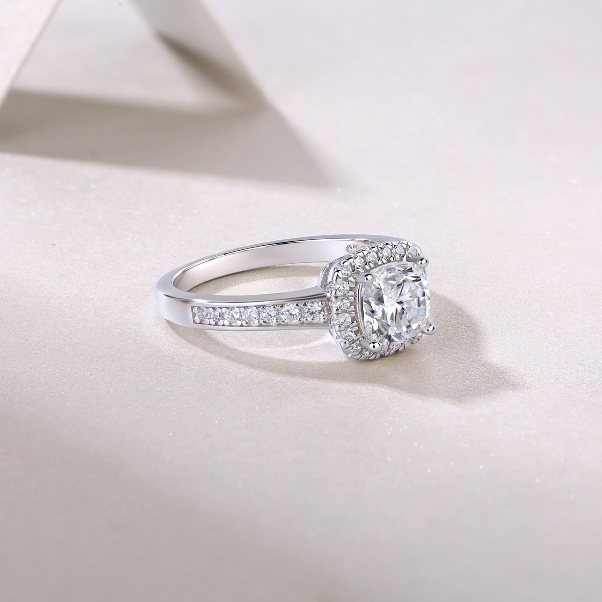 Side profile of cushion halo pavé moissanite engagement ring with pavé-lined band