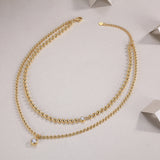 Close-up double-layer beaded necklace set: two strands with round blue gems, yellow gold