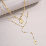 Layered lariat necklace with round coin medallion, blue moissanite accents, cross