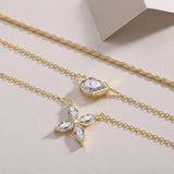 Close-up of gold-tone layered necklace with three chains and pear-cut crystal charms