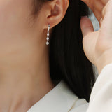 Three graduated round moissanite drop earrings on a hoop back, white gold vermeil