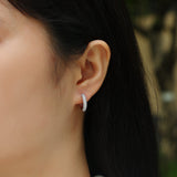 Triple pavé moissanite huggie hoop earrings, worn on ear—white gold vermeil