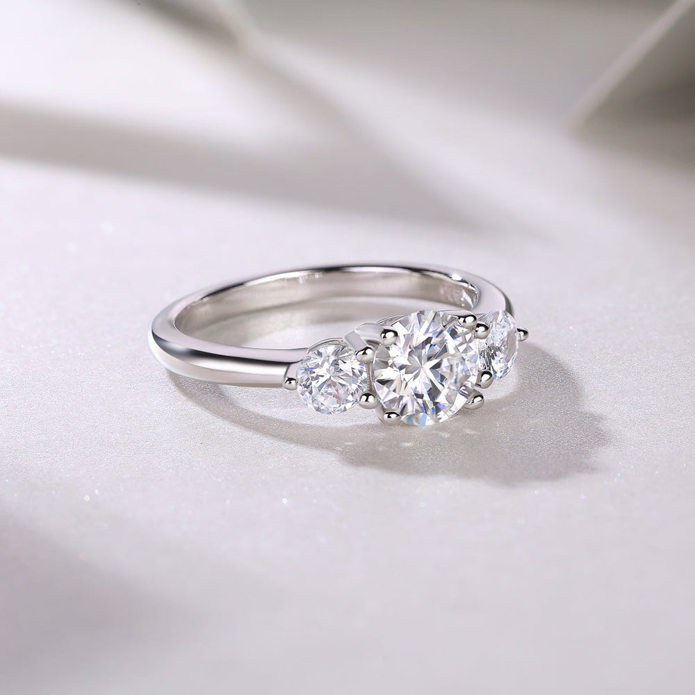 Side view of round three-stone moissanite engagement ring, white gold vermeil