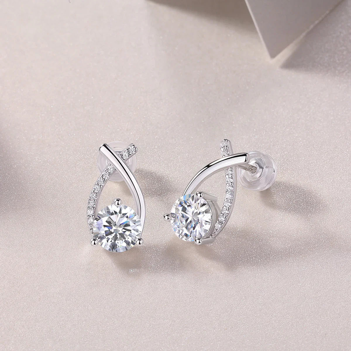 Teardrop moissanite stud earrings with curved ribbon pavé and round center stones