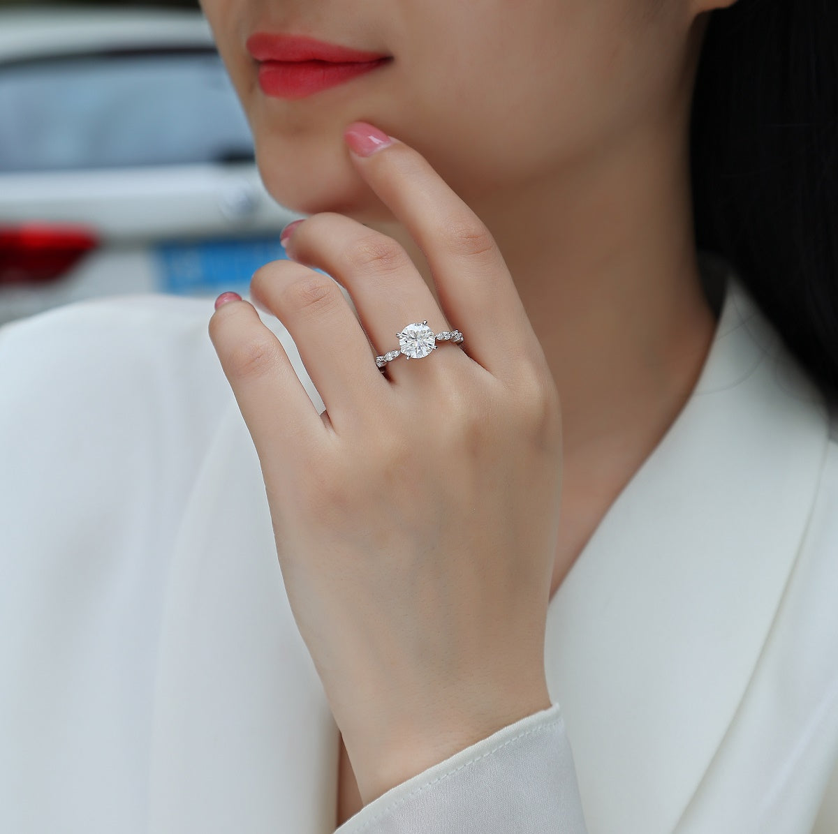 Round twist moissanite engagement ring on hand, white gold plated, round center and pavé band