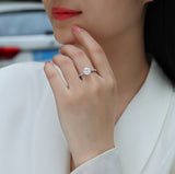 Round twist moissanite engagement ring on hand, white gold plated, round center and pavé band