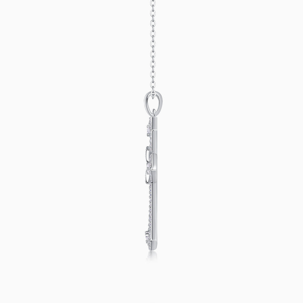 White gold tone cross pendant back view with bail and chain links, pavé details