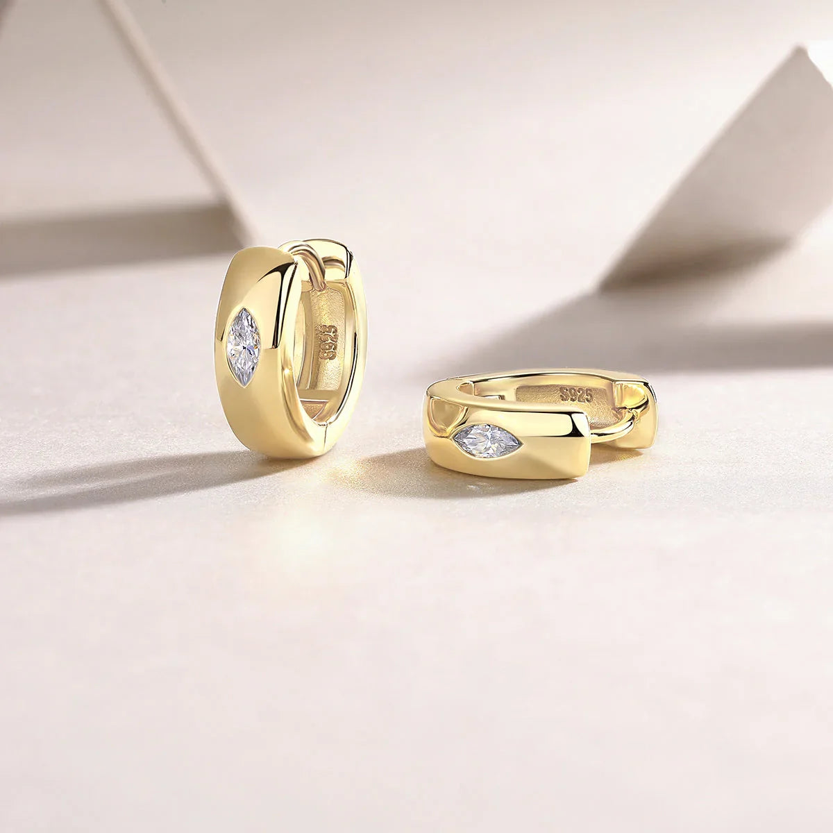 Chunky huggie hoop earrings, yellow gold vermeil; visible clasp and marquise stone