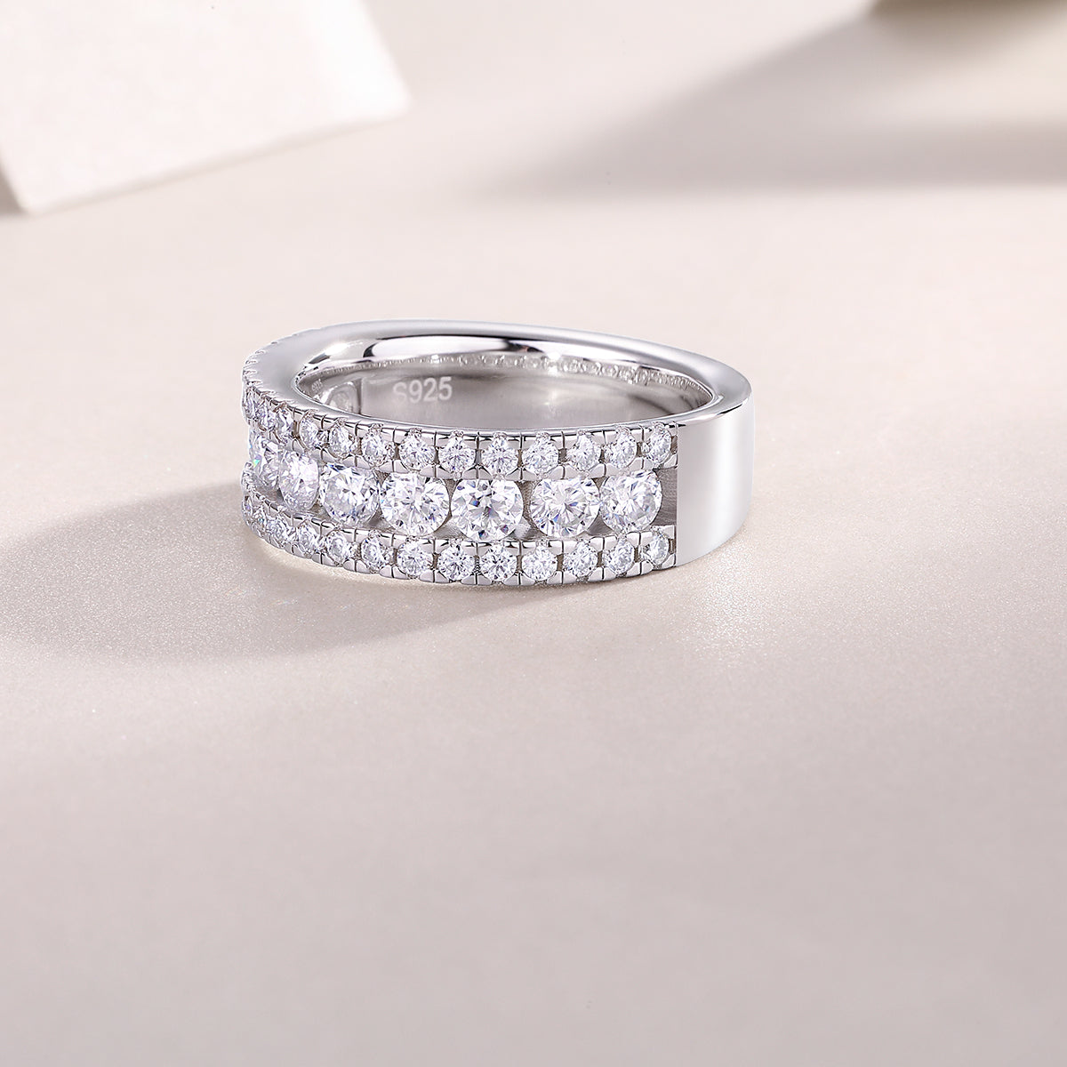 Inner view of moissanite half eternity band with metal hallmark and triple row stones