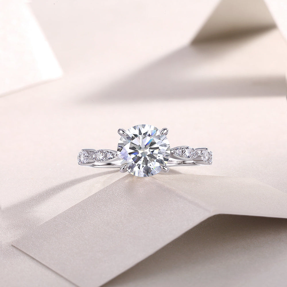 Round twist moissanite engagement ring with round center stone and pavé side accents