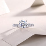Round twist moissanite engagement ring with round center stone and pavé side accents