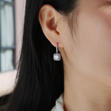 Cushion halo moissanite drop earrings on ear, white gold vermeil, square halo border