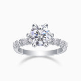 Six-prong pavé moissanite engagement ring with round center stone, white metal band