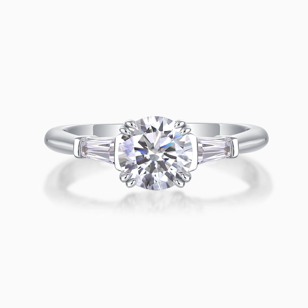 White metal three-stone ring with round center moissanite and baguette side stones