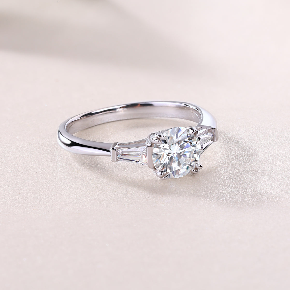 White metal three-stone engagement ring, round center with baguette side settings